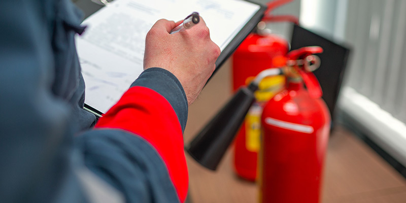 Inspecting fire safety equipment with checklist