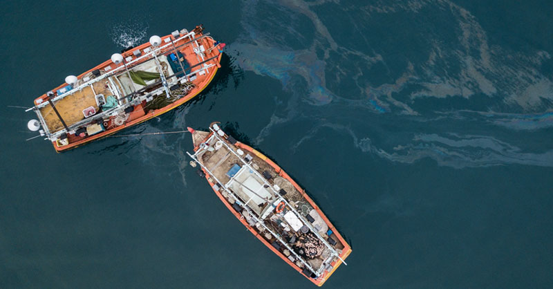 Image of two boats with oil slick behind it