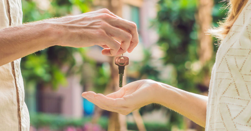 Male handing female house keys