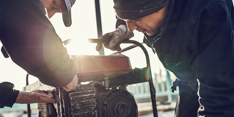 Two men working on portable generator