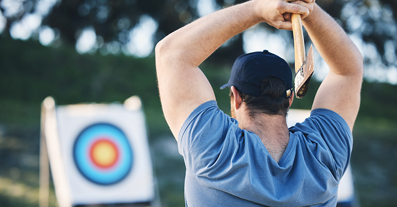 Man throwing tomahawk at a target