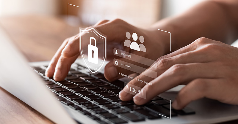 Person typing login credentials on laptop keyboard