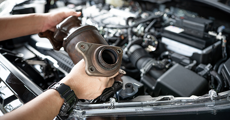 Man taking catalytic converter from car