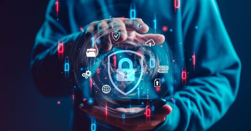 A person holds a smartphone projecting a holographic interface with digital security icons, including a lock, cloud, and binary code, against a dark, tech-themed background