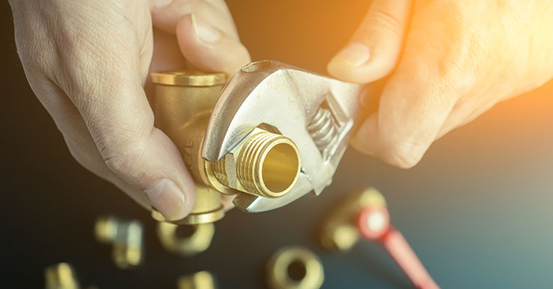 Man using ergonomic hand tool on plumbing piece