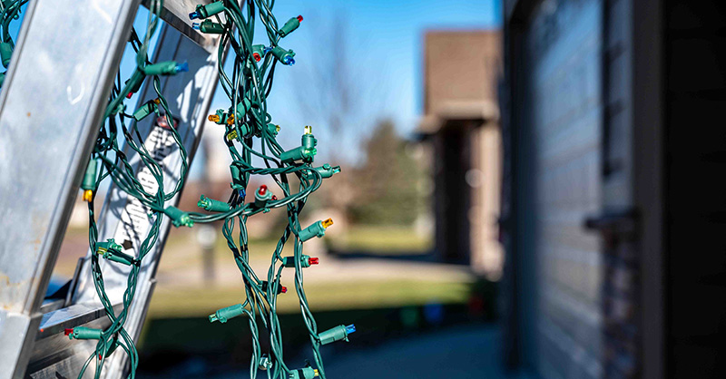 Holiday lights hanging on ladder outside business