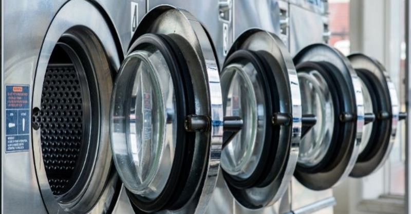 ow of industrial washing machines in a laundromat.