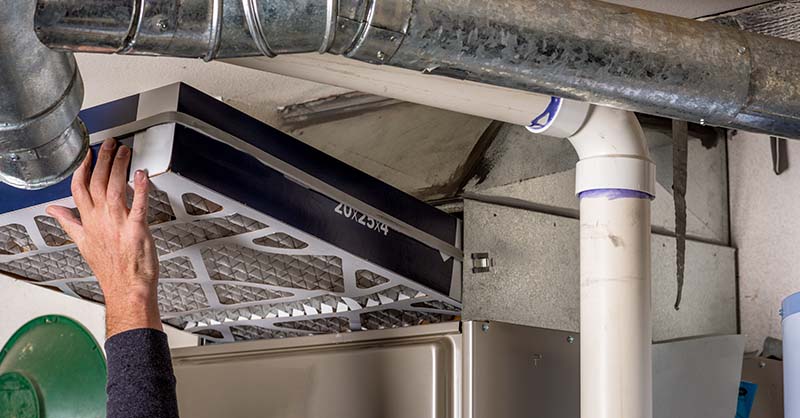 Man maintenancing furnace to help prevent furnace fire