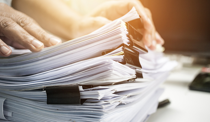 Businessman working on stack reports papers files on desk work in office, business paperwork or piles of unfinished documents achieves with paperclip on offices in business