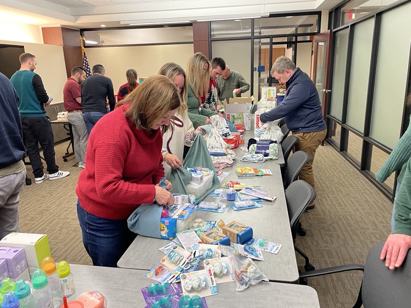 Team members standing at a table packing items