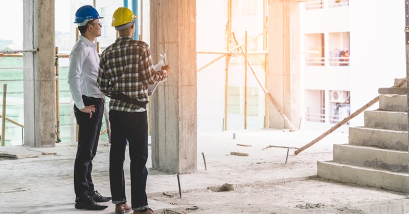 Two contractors standing looking at construction project progress