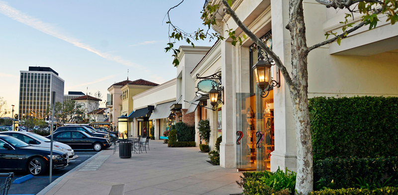 Shopping strip mall with cars parked outside