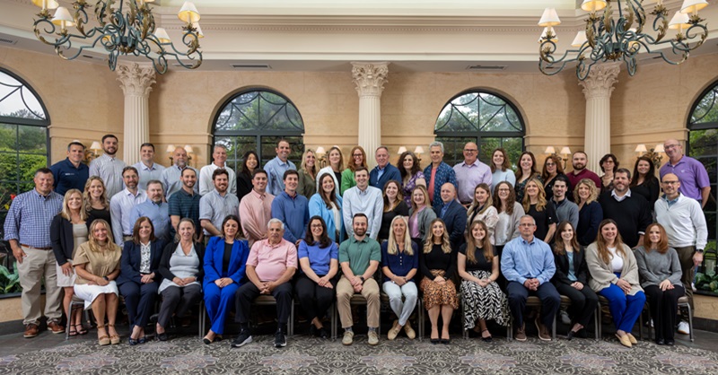 Group of business men and women posing for a photo