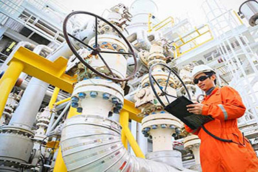An employee working next to an oil rig