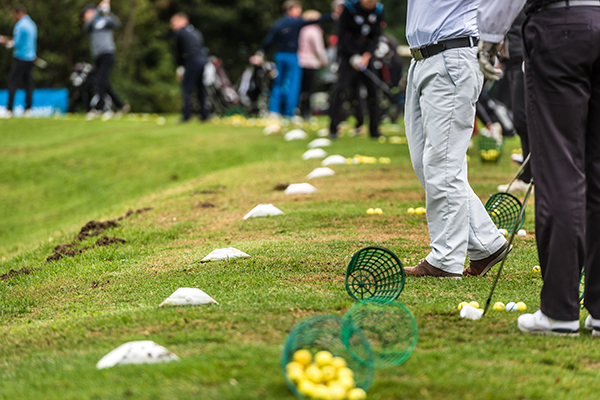 A golfer hitting golf balls at a golf range.