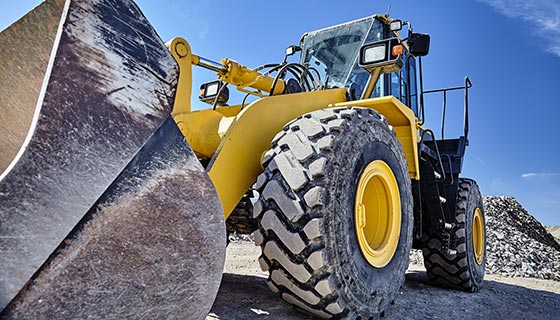 Front loader with gravel mound in the background