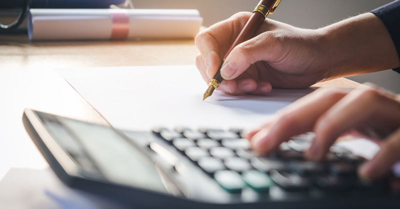Hands with pen and calculator