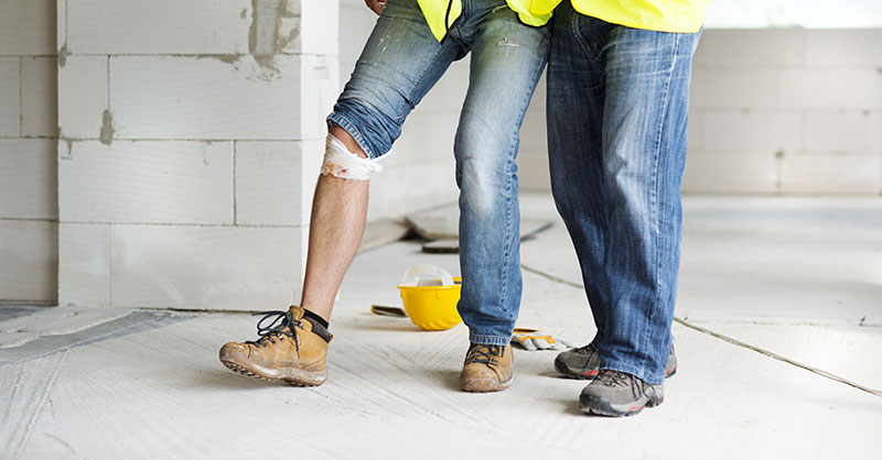 Construction worker helping injured co-worker